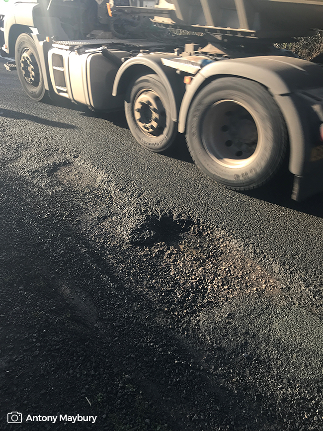Lorry driving by a pothole