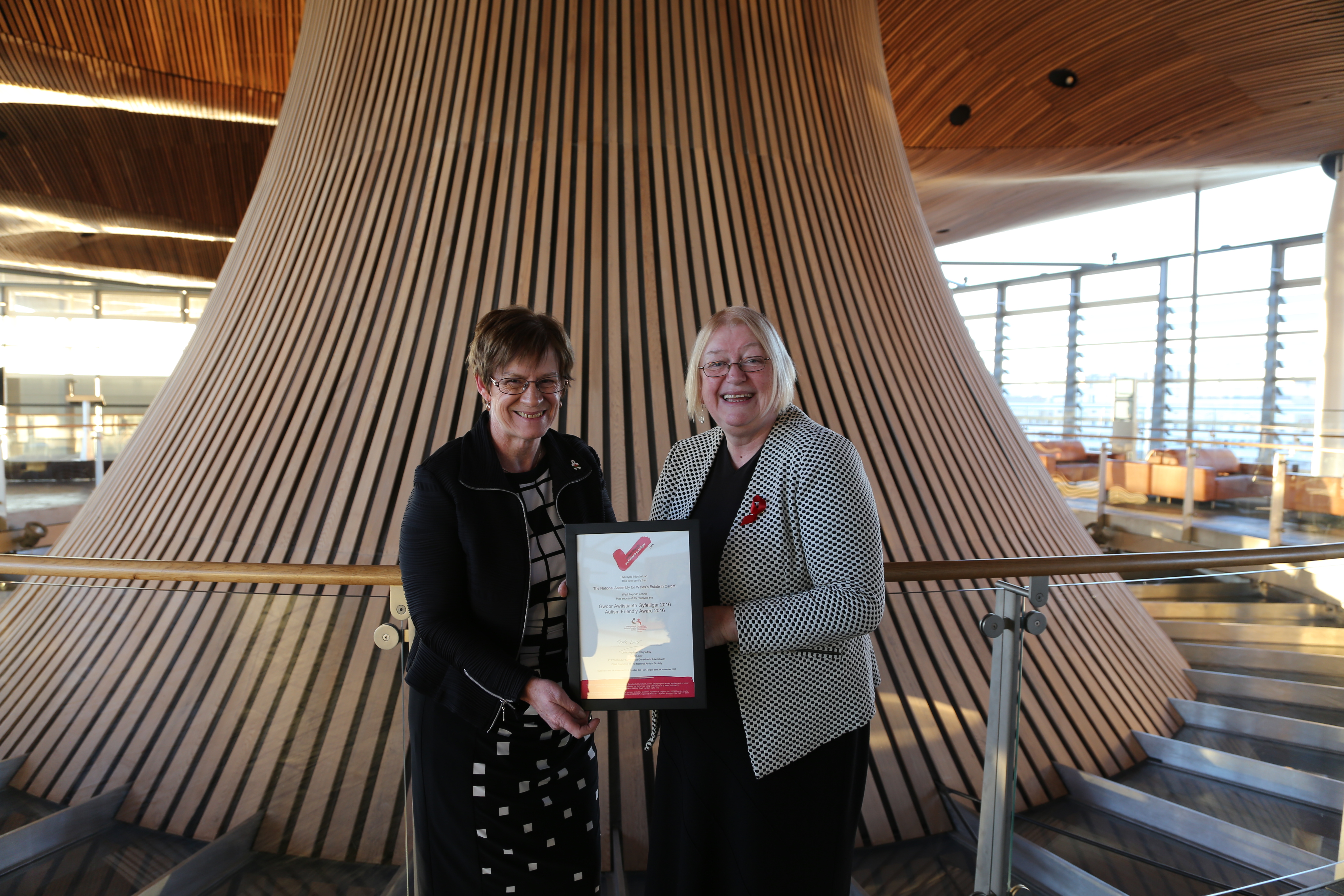 • Photo of Joyce Watson, AM and Ann Jones, Deputy Presiding Officer with the National Autistic Society Access Award certificate.
