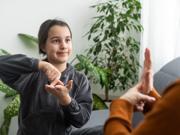 An image of a child signing with another person
