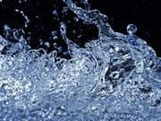 Close-up of splashing water with droplets frozen in motion against a dark background.
