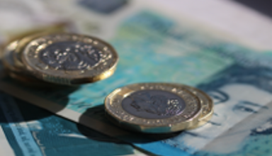 Pound coins and a five pound note.