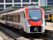 A Transport for Wales train waiting at the platform of a station.