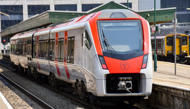 A Transport for Wales train waiting at the platform of a station.