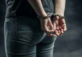 Hand behind a person’s back in Handcuffs