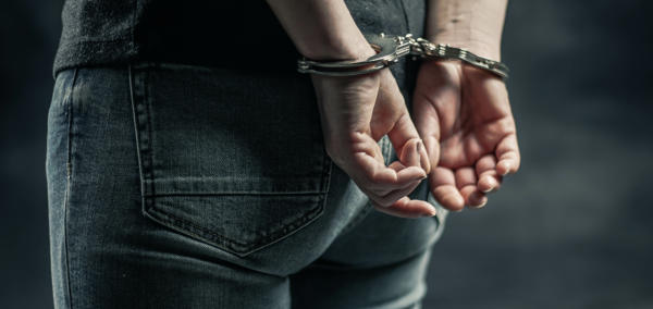 Hand behind a person’s back in Handcuffs