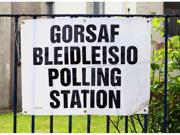 A sign tied to a fence. The text on the sign reads ‘Polling Station’.