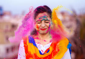The article’s main image is of a happy person celebrating the Indian festival of Holi with coloured powders.