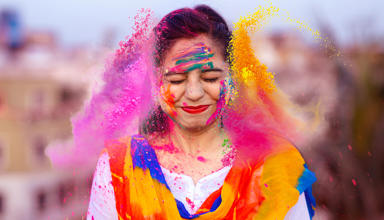 The article’s main image is of a happy person celebrating the Indian festival of Holi with coloured powders.
