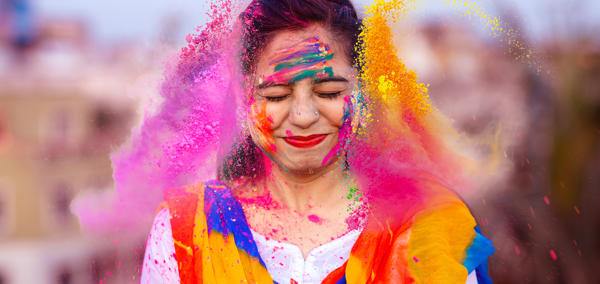 The article’s main image is of a happy person celebrating the Indian festival of Holi with coloured powders.