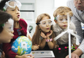 Children in a science lesson with one holding a small globe.