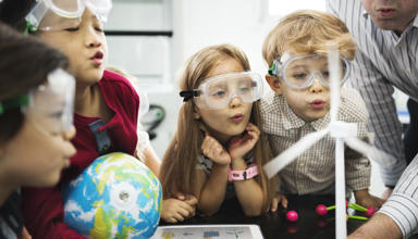 Children in a science lesson with one holding a small globe.
