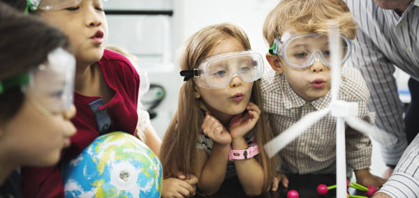 Children in a science lesson with one holding a small globe.