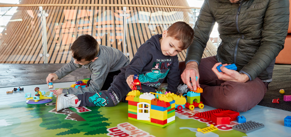 A parent and children play with building blocks in the Senedd play area