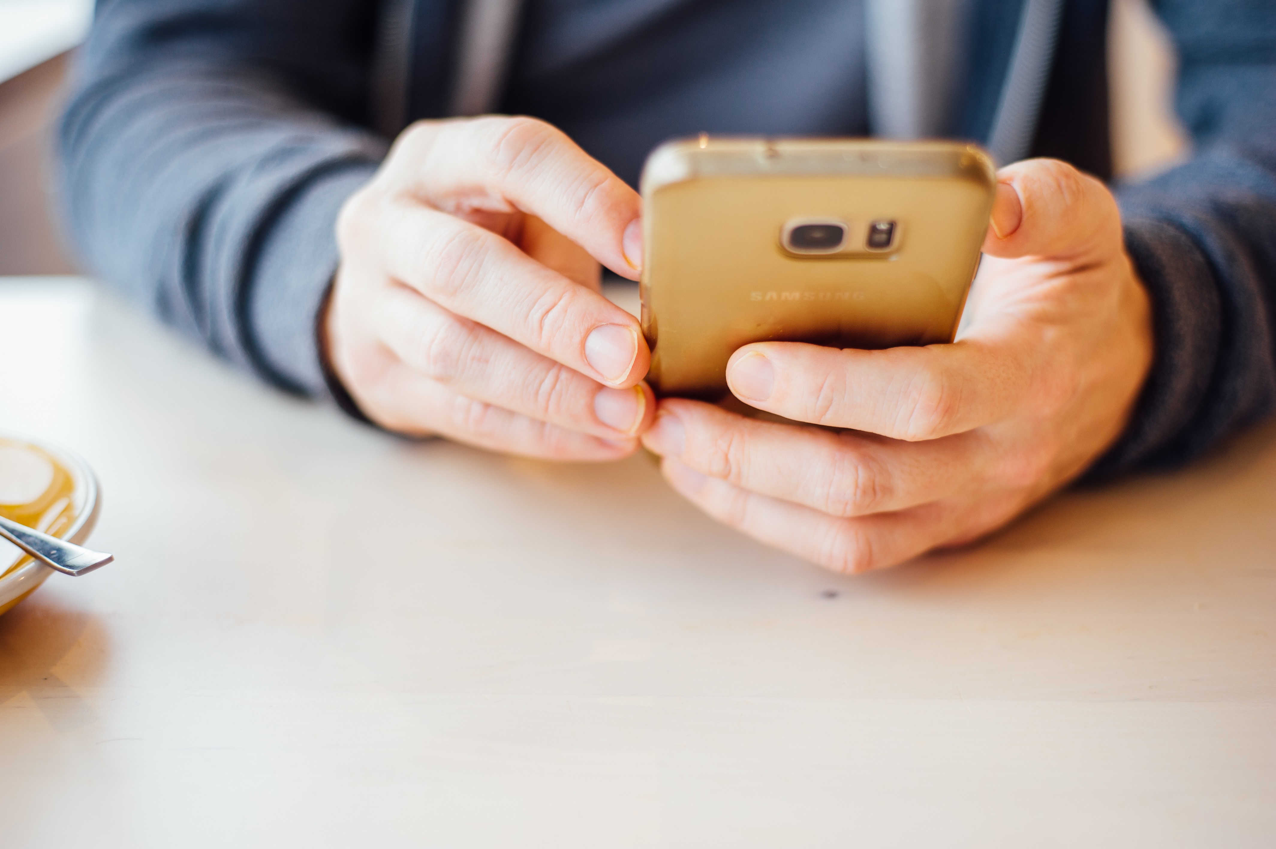 Close-up of hands using a mobile phone.