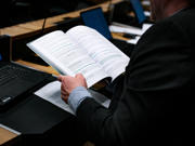This is an image of a person working at a desk reading a report.