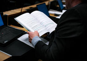 This is an image of a person working at a desk reading a report.