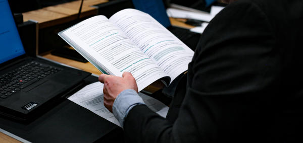 This is an image of a person working at a desk reading a report.