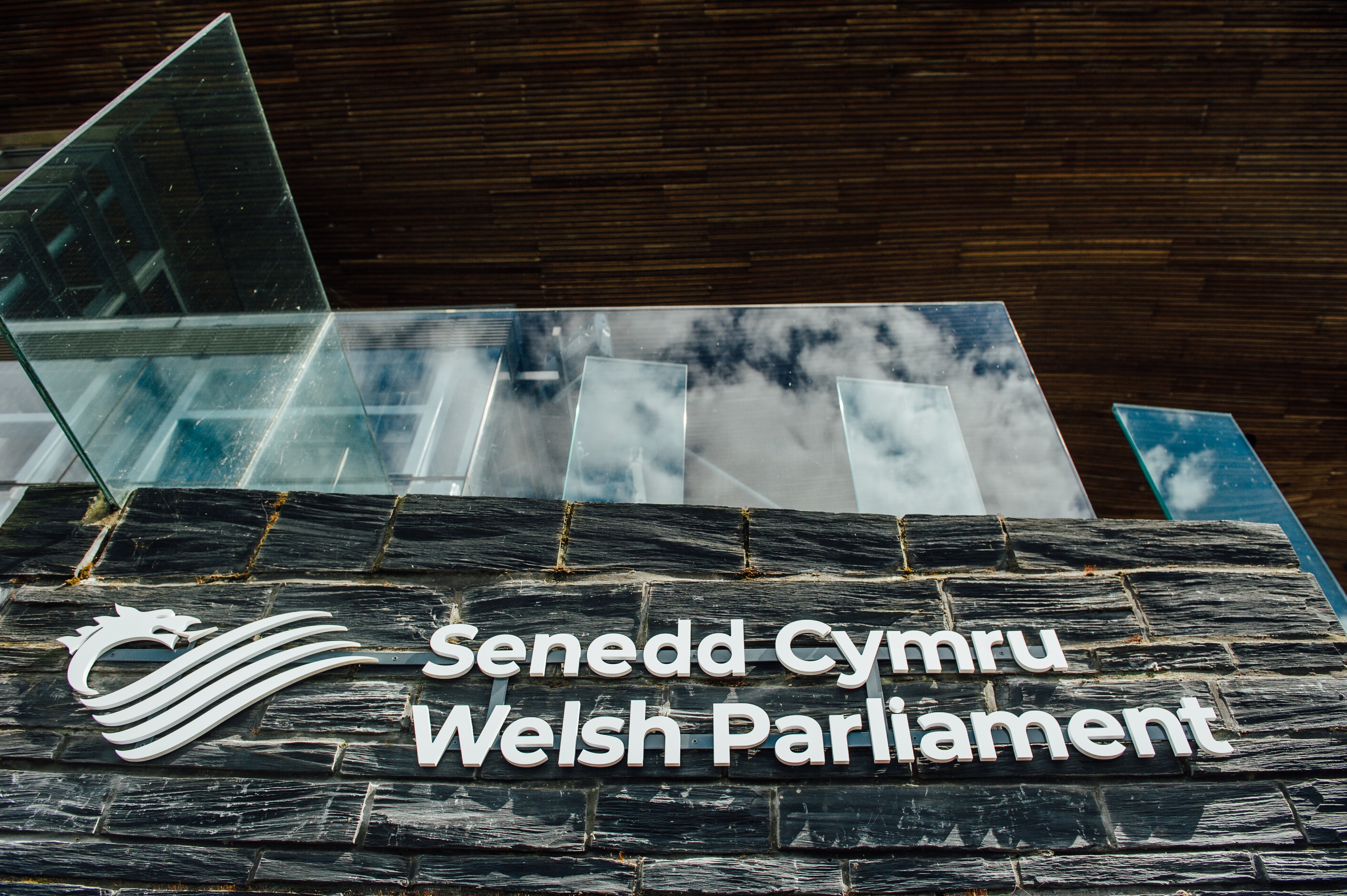 A Senedd Cymru/Welsh Parliament sign on the outside of the Senedd building
