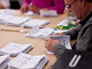 An image of someone counting votes at a Senedd election. 