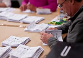 An image of someone counting votes at a Senedd election. 