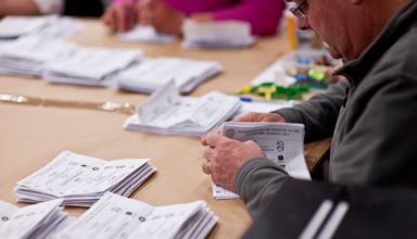 An image of someone counting votes at a Senedd election. 