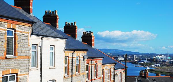 A picture of a row of terraced houses, with a city in the background.