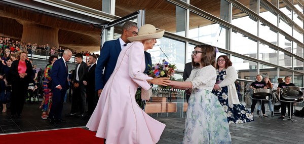Celyn Matthews-Williams presents a posy to The Queen at the Senedd
