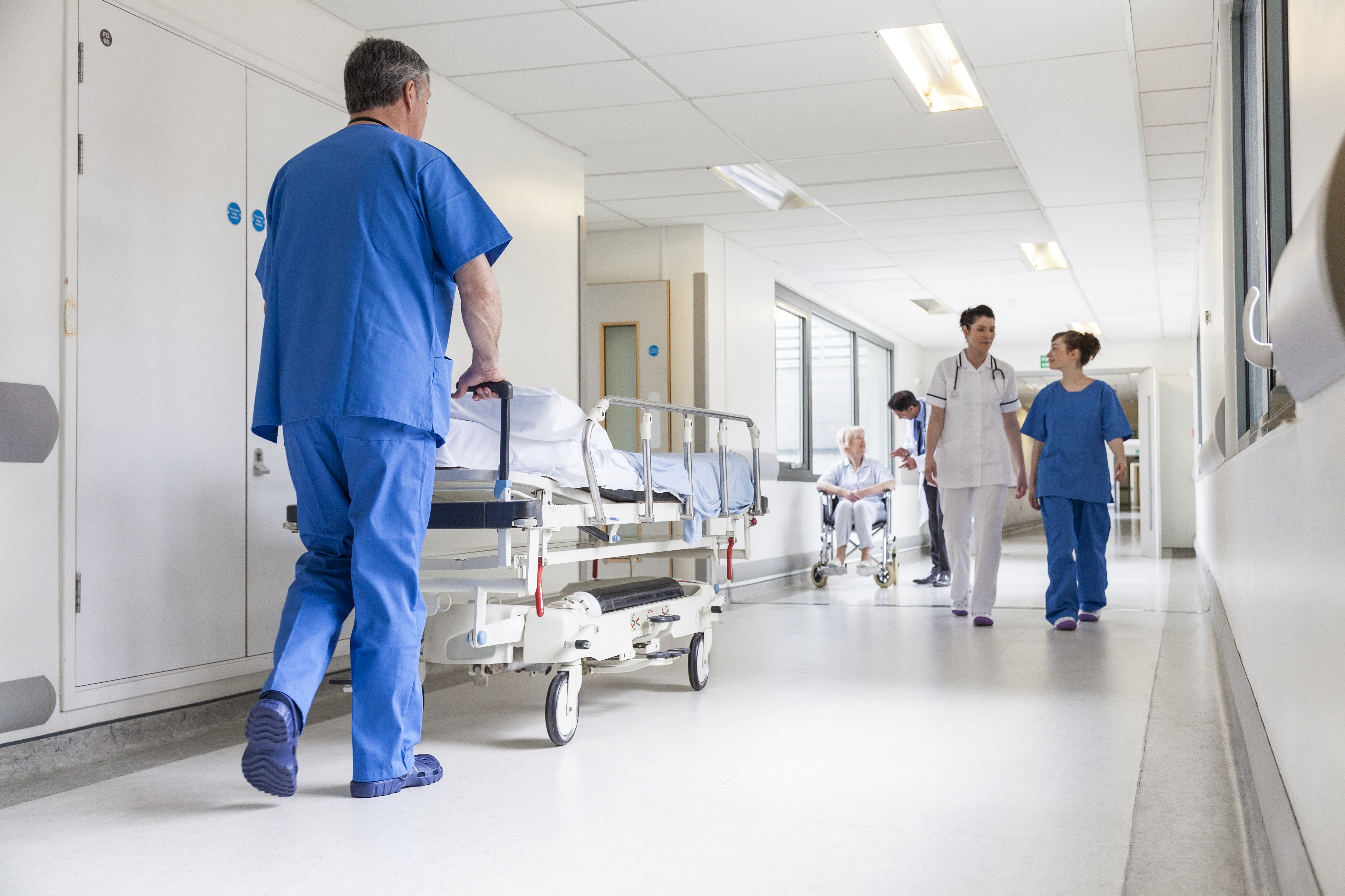 A hospital corridor, nurses are talking and caring for patients