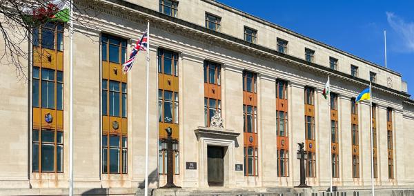 A picture of the outside of the government building in Cathays. The Welsh, UK and Ukraine flags are visible.