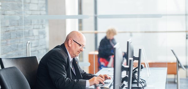 Person working on a computer on the Senedd reception desk.